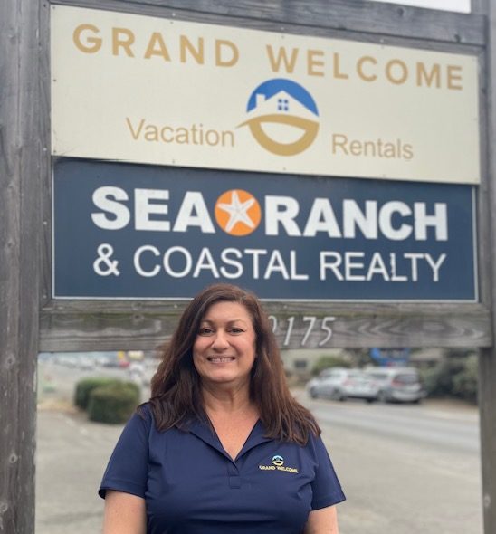 Kathleen Bennett standing in front of the Sea Ranch sign